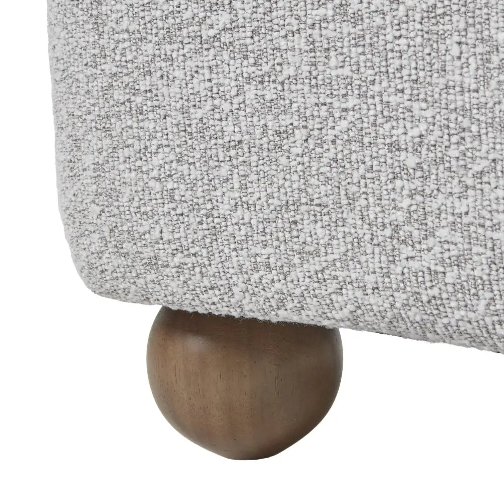 Leg of greige hui large arm chair showing gray textured fabric and round wooden foot for stylish support