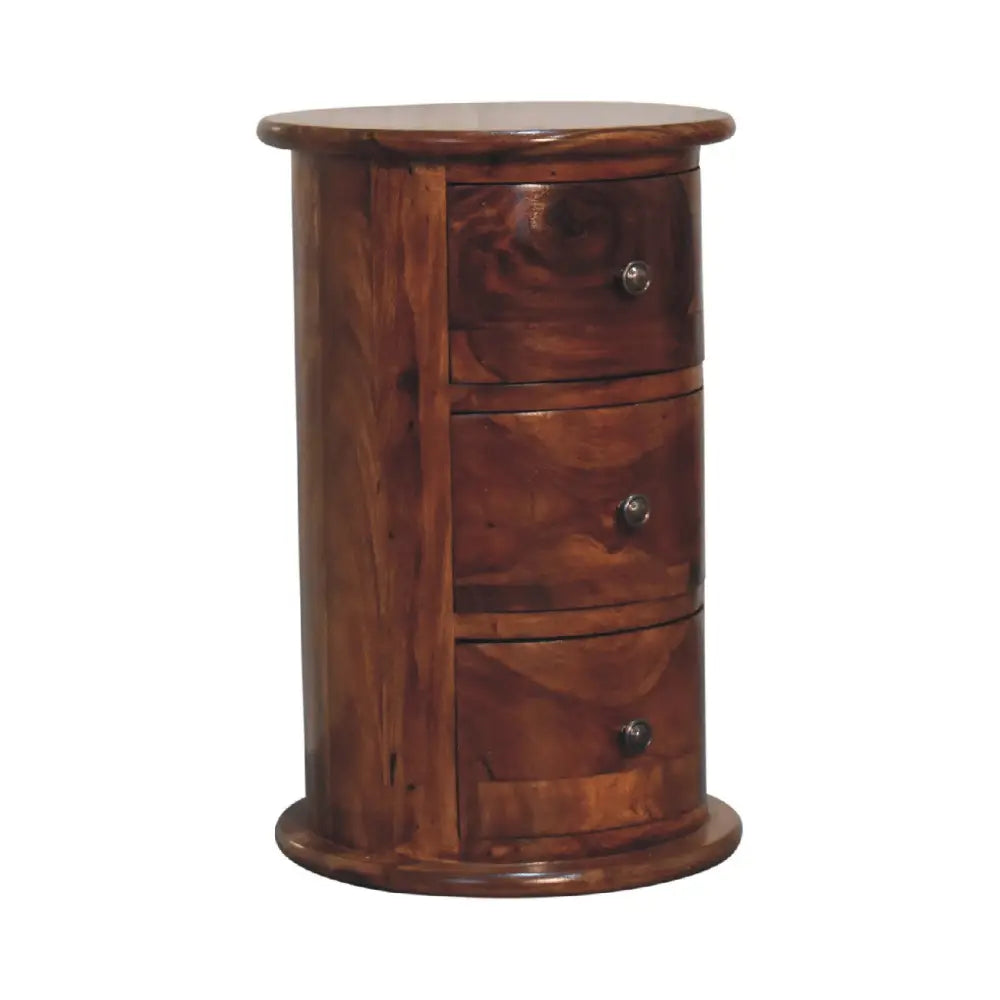 A cylindrical wooden nightstand with three drawers and round knobs in warm brown chestnut sheesham drum finish