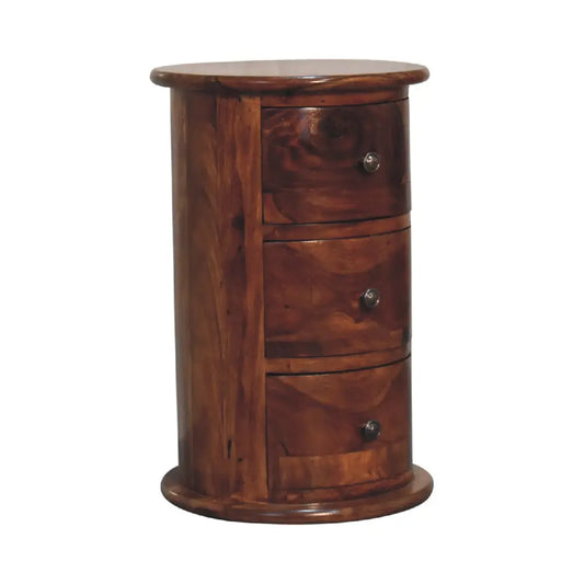 A cylindrical wooden nightstand with three drawers and round knobs in warm brown chestnut sheesham drum finish