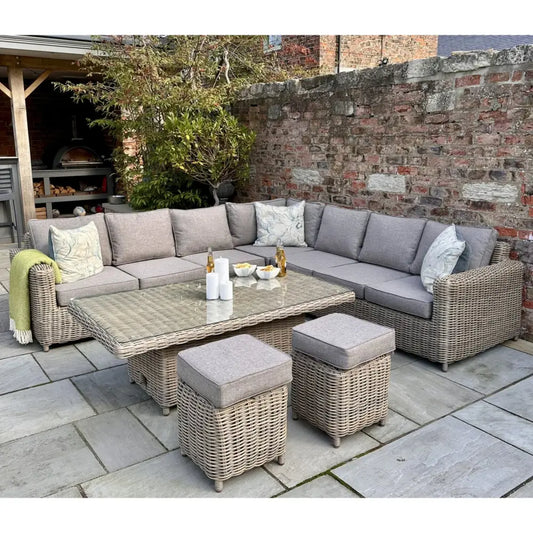 Gray wicker corner set with soft gray fabric cushions featuring a riser table and matching ottomans for outdoor use