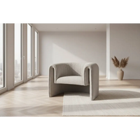 A sleek light gray upholstered avia mist armchair with modern curved design and tufted detailing