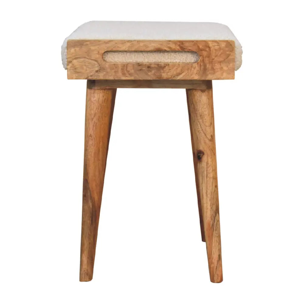 A boucle cream tray style footstool with a cream tray boucle upholstered seat and rustic wooden tapered legs