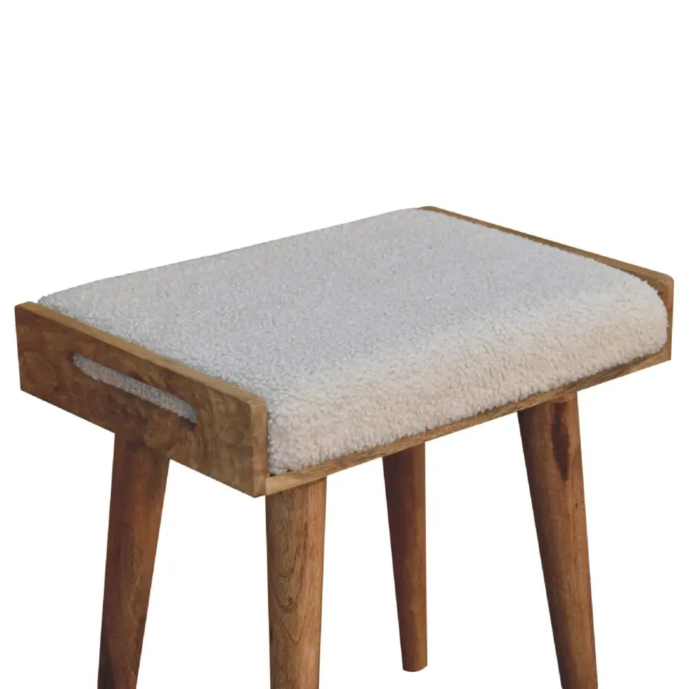 Cozy boucle cream tray style footstool with off-white sheepskin cushion and natural wood tapered legs