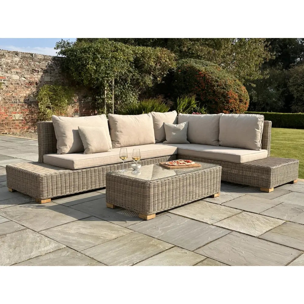 Beige cushioned outdoor sectional sofa with woven wicker frame and matching ottoman from capri collection large corner coffee table set