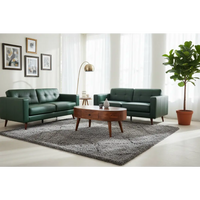 Emerald green leather sofa set with tufted upholstery and tapered wooden legs beside a chestnut rounded coffee table