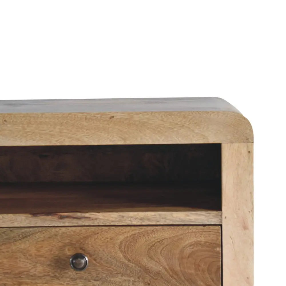 Chunky oak-ish floating bedside with light wood single drawer and curved top edge featuring a dark metal knob