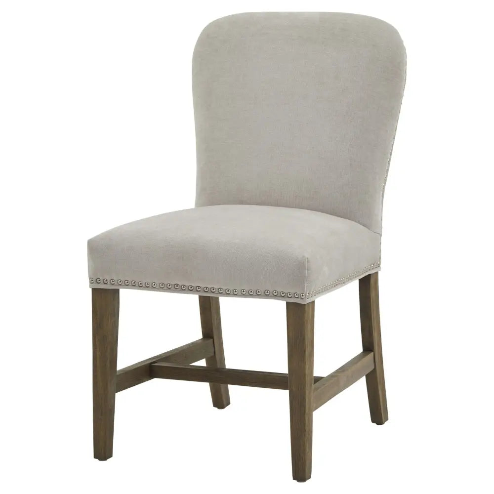 Beige upholstered cobham grey dining chair with wooden legs and decorative nailhead trim for stylish dining