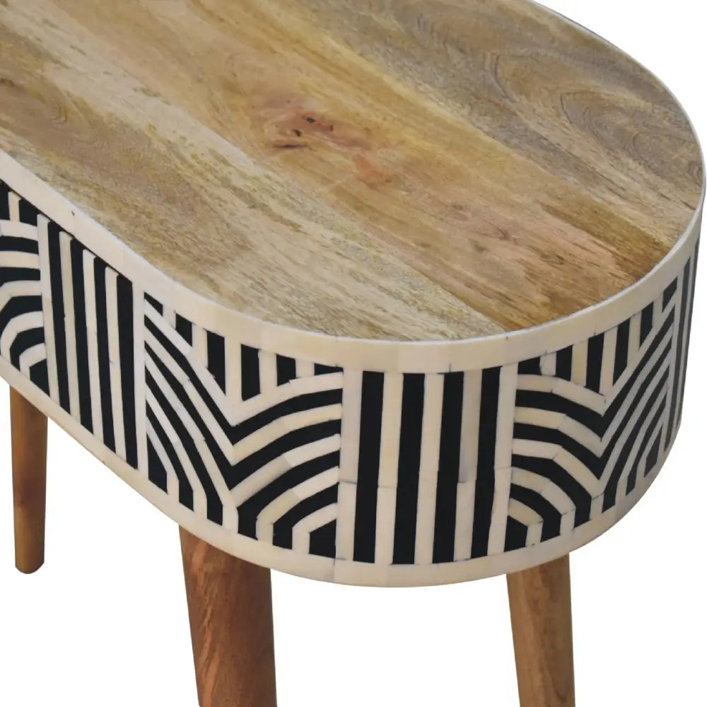 Oval coffee table with natural wood top and black and white geometric edessa bone inlay console sides and wooden legs