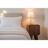 Extra mini curved chestnut bedside warm-toned wood nightstand with two drawers and brass lamp with cream shade