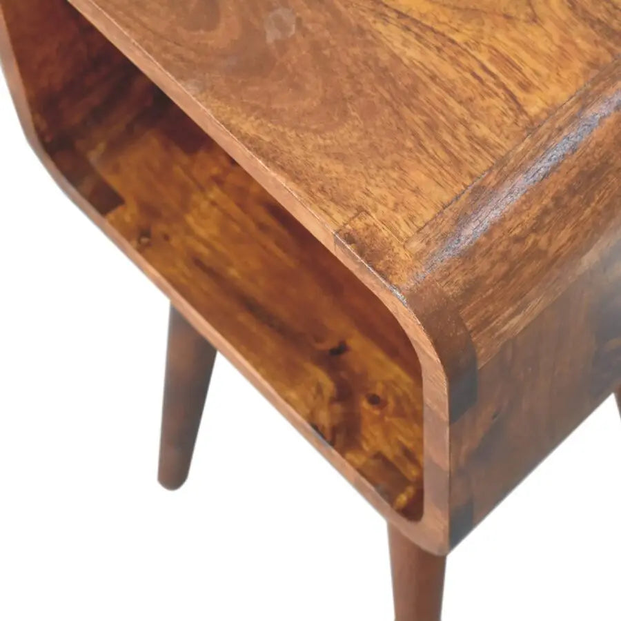Mini chestnut curved warm medium brown wooden side table with curved top and tapered legs as a curved open bedside