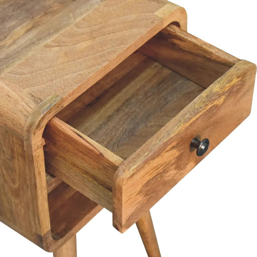 A rustic mini oak-ish curve lower bedside wooden nightstand with one drawer and warm brown tones