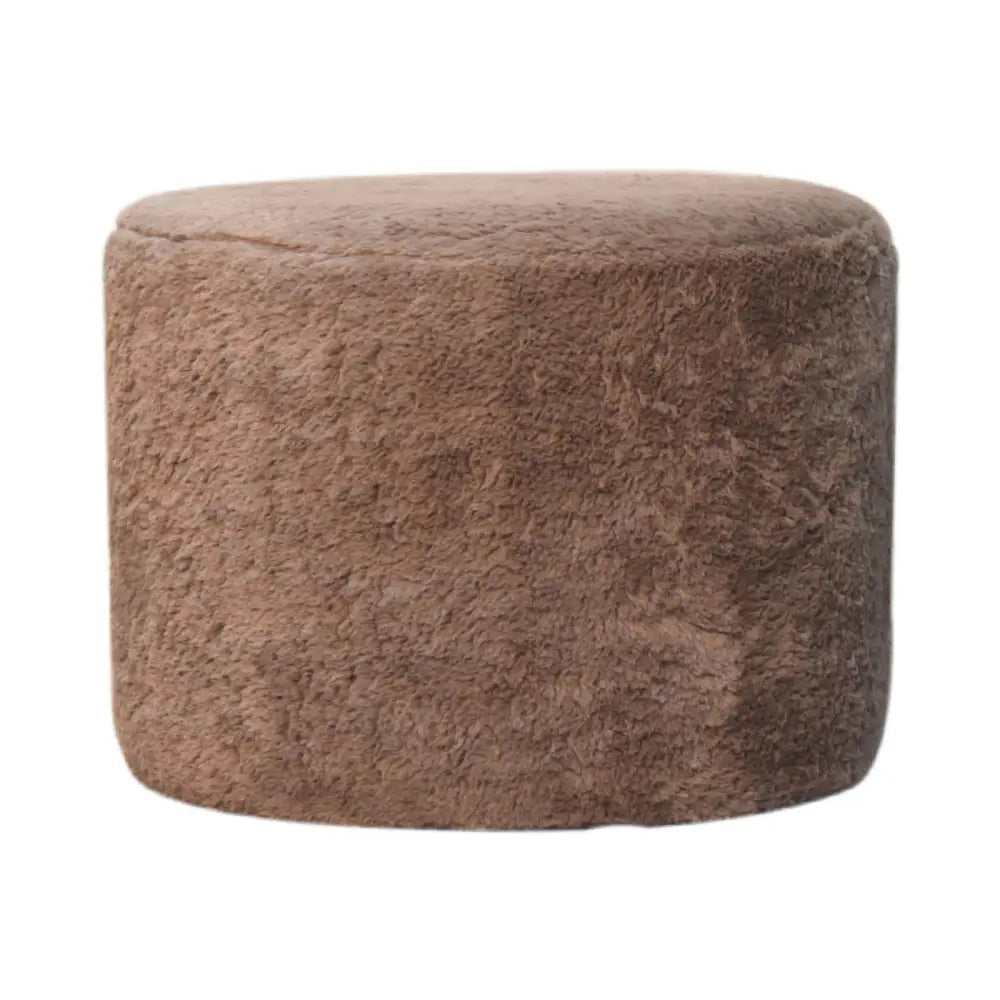 A plush mocha faux fur round footstool with a soft textured surface perfect as a cozy ottoman or footrest