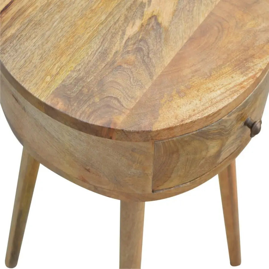 Nordic circular bedside table in natural wood with visible grain patterns and four tapered legs for a cozy look