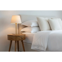 Minimalist nordic circular bedside table in wood with a single drawer and brass table lamp with beige shade