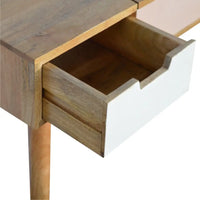 A modern wooden dressing table with natural wood finish and white drawer fronts in a pink gradient dressing setup