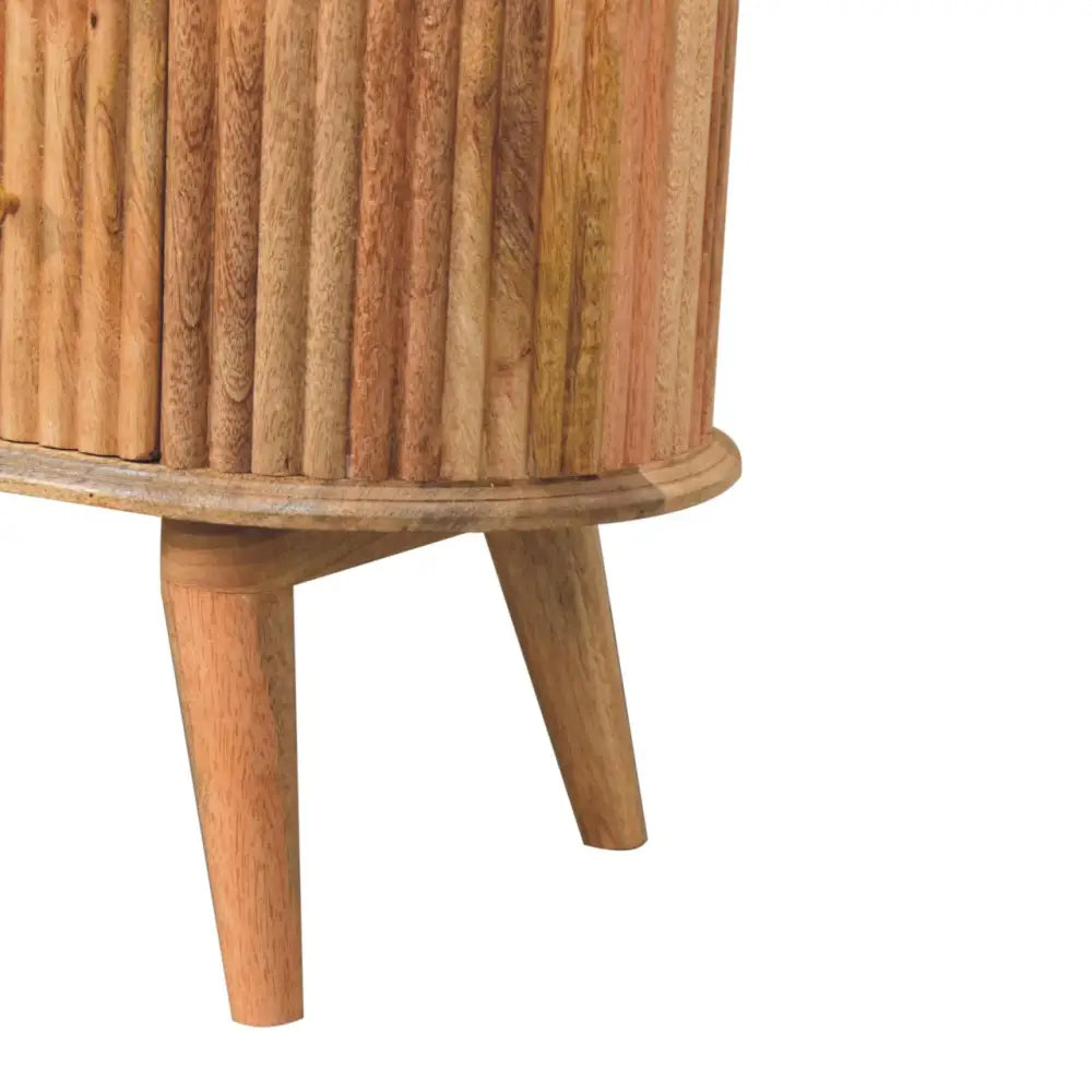 A cylindrical wooden side table with vertical slats and tapered legs in light brown natural wood called soba nordic chest