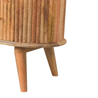 A cylindrical wooden side table with vertical slats and tapered legs in light brown natural wood called soba nordic chest