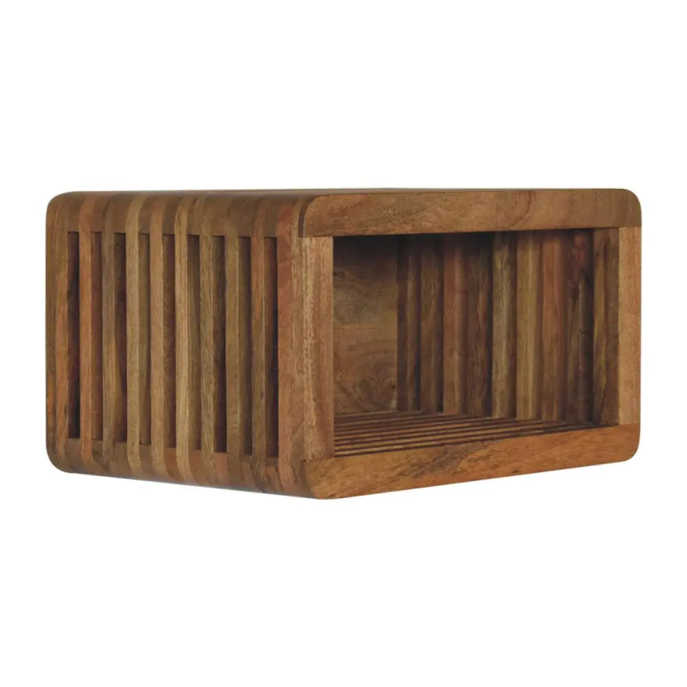 A rectangular wooden wall mounted bedside shelf with vertical slats and a warm natural wood finish