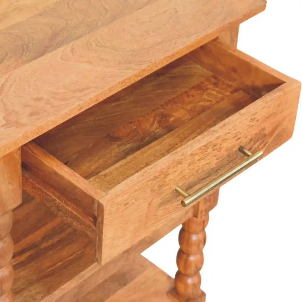 Light brown solid mango wood spindle side table with single drawer and brass handle on turned wood legs