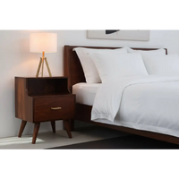 T-bar raised bedside nightstand in dark wood with tapered legs and a brass handle on one drawer
