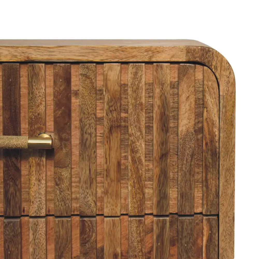 A rustic wooden t-bar ridged bedside cabinet with vertical brown slats and a brass handle for bedroom storage