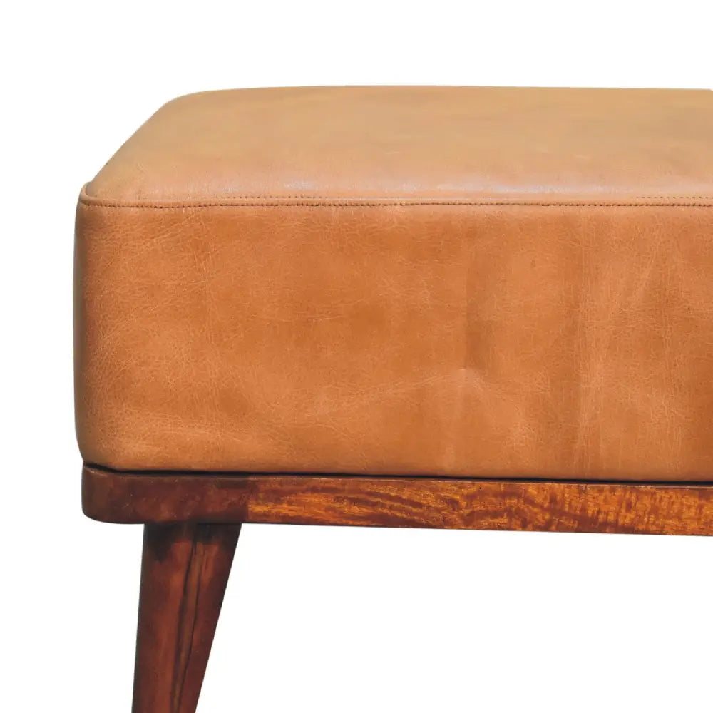 Tan buffalo leather ottoman with a wooden base and tapered legs perfect as a footstool or extra seating