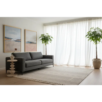 Gray upholstered sofa with clean lines and dark legs next to the bellis marble accent table with solid mango wood base