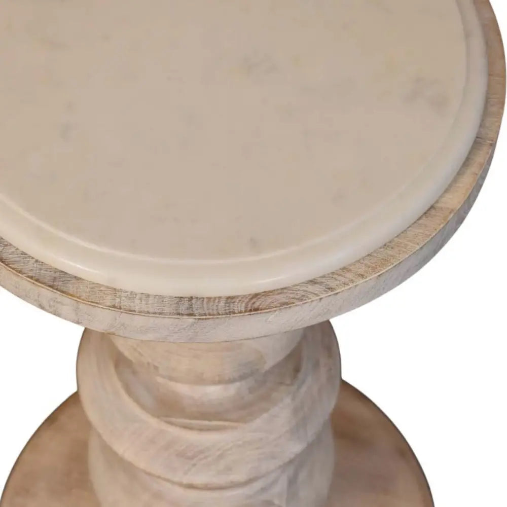The bellis marble accent table is a round off-white marble accent table with a distressed solid mango wood base