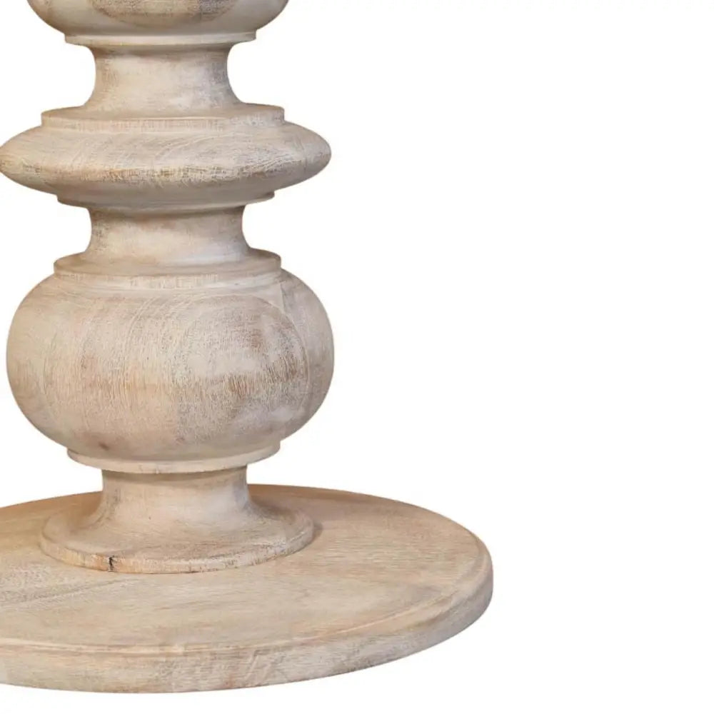 The bellis marble accent table features a light distressed wood pedestal base made of solid mango wood with ornate tiered design