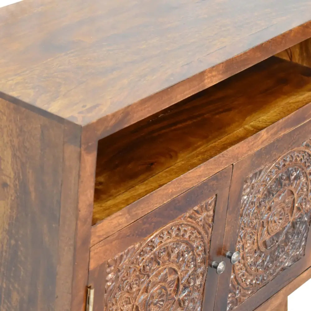 Dark brown wooden tova open shelf cabinet with carved floral doors and silver knobs in an open shelf design