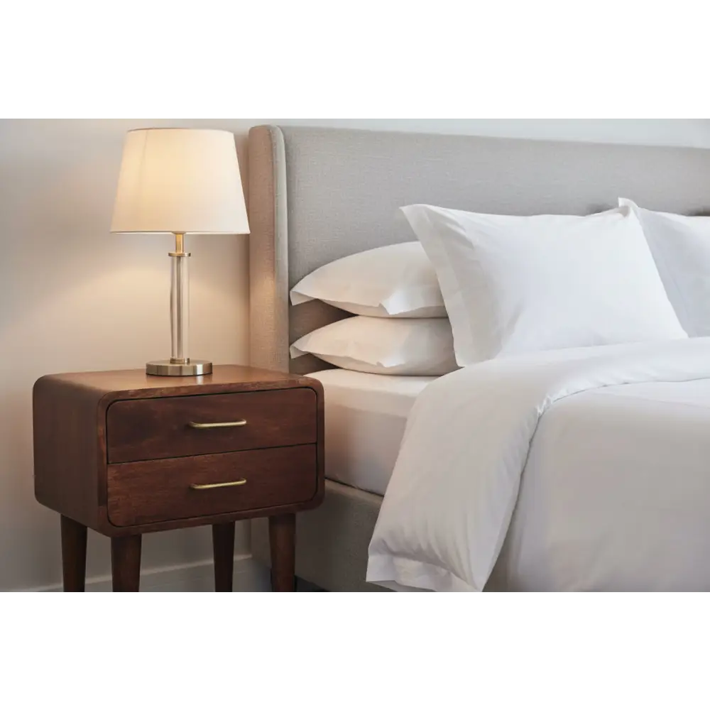 Warm-toned brass lamp with cream fabric shade on dark solid mango wood valenza two-drawer bedside table