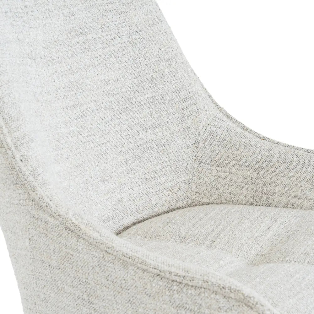 A soft light gray textured fabric zephra dining chair with a modern curved design perfect for any dining space