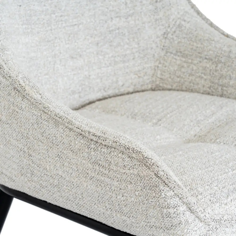 A cozy zephra dining chair with light gray textured fabric and a sleek black metal frame perfect for dining rooms