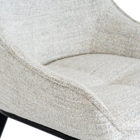 A cozy zephra dining chair with light gray textured fabric and a sleek black metal frame perfect for dining rooms