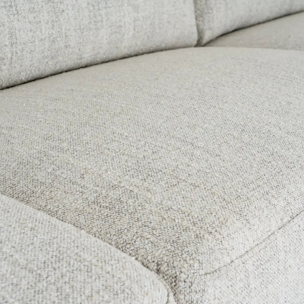 Light gray textured fabric cushion with woven material and subtle stitching on zephra three seater sofa