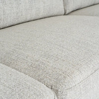 Light gray textured fabric cushion with woven material and subtle stitching on zephra three seater sofa